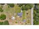 Aerial view of a house with a screened-in patio and multiple outbuildings on a large lot with mature trees at 21551 Lake Seneca Rd, Eustis, FL 32736