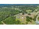 Aerial view of a home with a well-kept lawn, outbuildings, and surrounded by lush trees in a rural setting at 21551 Lake Seneca Rd, Eustis, FL 32736