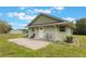 View of the backyard with a concrete patio and exterior access door at 21551 Lake Seneca Rd, Eustis, FL 32736
