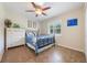 Comfortable bedroom with blue quilt, ceiling fan, white dresser, art, and window to the outdoors at 21551 Lake Seneca Rd, Eustis, FL 32736