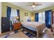 Bedroom with a ceiling fan, hardwood floors, and natural light from two windows at 21551 Lake Seneca Rd, Eustis, FL 32736