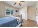 This bedroom features a ceiling fan, a window, and a comfortable bed with a blue quilt at 21551 Lake Seneca Rd, Eustis, FL 32736