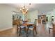 Bright dining room with wooden table, decorative chandelier, and an open view to the living area at 21551 Lake Seneca Rd, Eustis, FL 32736