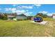 A blue truck is parked beside this single-story home, boasting lush green lawns and a serene backyard at 21551 Lake Seneca Rd, Eustis, FL 32736