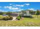 The back of the home with a screened patio, complemented by a well-maintained lawn and beautiful landscaping at 21551 Lake Seneca Rd, Eustis, FL 32736