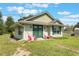 Charming home with green doors and shutters, complemented by a well-maintained lawn and inviting front patio at 21551 Lake Seneca Rd, Eustis, FL 32736