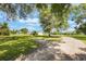 Exterior view of the home featuring the driveway and expansive front lawn with trees at 21551 Lake Seneca Rd, Eustis, FL 32736