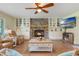 Inviting living room with a stone fireplace, built-in cabinets, and lots of natural light at 21551 Lake Seneca Rd, Eustis, FL 32736