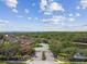 Gated community entrance with lush landscaping, townhomes, and pond in the distance at 5935 Tivoli Gardens Blvd, Orlando, FL 32829