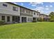 Manicured backyard with lush green grass and a view of the building's exterior at 5935 Tivoli Gardens Blvd, Orlando, FL 32829
