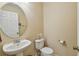 This half bathroom has an oval mirror and pedestal sink that adds a touch of elegance at 5935 Tivoli Gardens Blvd, Orlando, FL 32829