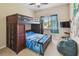 Bright bedroom featuring a wooden bunk bed, blue accents, and a large window at 5935 Tivoli Gardens Blvd, Orlando, FL 32829