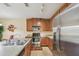 Kitchen boasts stainless steel appliances, wood cabinetry, and a granite countertop at 5935 Tivoli Gardens Blvd, Orlando, FL 32829