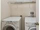 Functional laundry room equipped with a washer, dryer, and wire shelving for storage at 5935 Tivoli Gardens Blvd, Orlando, FL 32829
