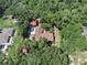 Aerial view of a charming home nestled among lush trees, with outbuildings, showcasing its expansive lot at 1625 Itchepackesassa Dr, Lakeland, FL 33810