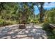 Paver patio with a fire pit and a wood storage shed, surrounded by green vegetation at 1625 Itchepackesassa Dr, Lakeland, FL 33810