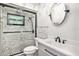 Beautiful bathroom with a glass shower, light stone accent wall, and a round mirror at 1625 Itchepackesassa Dr, Lakeland, FL 33810