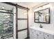 Bathroom featuring sliding barn door, gray vanity, and tiled shower at 1625 Itchepackesassa Dr, Lakeland, FL 33810