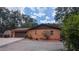Side view of the charming house with a detached garage and well-maintained landscaping at 1625 Itchepackesassa Dr, Lakeland, FL 33810