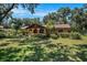 Charming single-story house featuring an arched entry and lush front yard shaded by mature trees at 1625 Itchepackesassa Dr, Lakeland, FL 33810