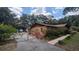 Gated driveway and exterior view of the house featuring an orange facade at 1625 Itchepackesassa Dr, Lakeland, FL 33810