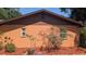 Charming stucco home exterior featuring a unique sun decoration and well-maintained landscaping at 1625 Itchepackesassa Dr, Lakeland, FL 33810