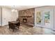 Cozy living room with a brick fireplace, wood mantel, and glass doors at 1625 Itchepackesassa Dr, Lakeland, FL 33810