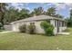 The backyard features a screened lanai with a concrete patio and lush landscaping, offering privacy and outdoor enjoyment at 130 E Pendleton Ave, Eustis, FL 32726