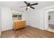 Relaxing bedroom featuring wood-look flooring, a ceiling fan, and a bright window at 130 E Pendleton Ave, Eustis, FL 32726