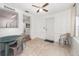 Sunny dining space showcasing neutral tile, white walls, a window, and an open transition to the kitchen and a door at 130 E Pendleton Ave, Eustis, FL 32726