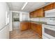 This functional kitchen features wooden cabinets, modern appliances, granite countertops, and laminate flooring for easy maintenance at 130 E Pendleton Ave, Eustis, FL 32726