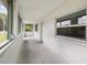 Enclosed lanai with multiple windows, concrete flooring and a white exterior door offers a bright transition to the outdoors at 130 E Pendleton Ave, Eustis, FL 32726