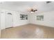 Spacious living room showcasing neutral tile flooring, a ceiling fan, bright windows, and a white front door at 130 E Pendleton Ave, Eustis, FL 32726