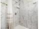 Elegant shower featuring marble-patterned tile, a shower curtain, and modern fixtures at 130 E Pendleton Ave, Eustis, FL 32726