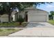 Inviting single-story home with a well-manicured lawn, two-car garage, and a red front door at 1416 Silverthorn Dr, Orlando, FL 32825