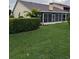 A green backyard with a screened lanai is enhanced by a manicured hedge at 2202 Garden Lake Dr, Winter Haven, FL 33884