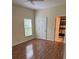 Bedroom with hardwood floors, a white ceiling fan, a window, and an adjoining bathroom at 2202 Garden Lake Dr, Winter Haven, FL 33884