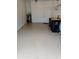 Garage with epoxy flooring, water heater, shelving and two trash cans at 2202 Garden Lake Dr, Winter Haven, FL 33884