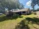 Spacious backyard featuring mature trees and ample green space, complemented by a partial view of the home's exterior at 2921 Se 38 Pl, Ocala, FL 34480