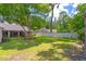 Large backyard showcasing green grass, mature trees, and a white privacy fence at 2921 Se 38 Pl, Ocala, FL 34480