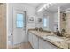 Bright bathroom featuring double sinks with granite countertops, decorative lighting, and exterior access at 2921 Se 38 Pl, Ocala, FL 34480