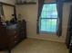 Clean bedroom with a dresser set and window, offering natural light and a comfortable atmosphere at 2921 Se 38 Pl, Ocala, FL 34480