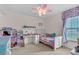 A bedroom features a colorful bed, workstation, ceiling fan, and built-in shelving at 2921 Se 38 Pl, Ocala, FL 34480