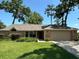Charming single-story home with a well-manicured lawn, mature trees, and an attached two-car garage at 2921 Se 38 Pl, Ocala, FL 34480