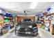 Well-lit garage with a black car parked inside with organized shelves and storage bins along the walls at 2921 Se 38 Pl, Ocala, FL 34480