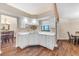 Bright kitchen with white cabinets, wood-look flooring, stainless sink and view to dining area at 2921 Se 38 Pl, Ocala, FL 34480