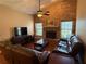 Cozy living room with a striking brick fireplace, vaulted ceilings, and comfortable leather furnishings at 2921 Se 38 Pl, Ocala, FL 34480