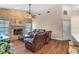 Cozy living room with a brick fireplace, ceiling fan, wood floors, and leather recliners at 2921 Se 38 Pl, Ocala, FL 34480