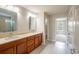 Elegant bathroom with double vanity, tan countertops, and neutral-colored cabinets at 383 Blue Lake Cir, Kissimmee, FL 34758