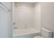 Bright bathroom featuring a tiled shower-tub combo with modern fixtures and a white toilet at 383 Blue Lake Cir, Kissimmee, FL 34758